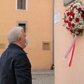 powiększ zdjęcie: Znicze i kwiaty przed tablicą upamiętniającą Jerzego Szmajdzińskiego