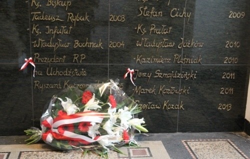 Kwiaty przy tablicach upamiętniających Jerzego Szmajdzińskiego i Ryszarda ...
