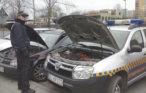 Strażnicy miejscy pomagają uruchomić samochód