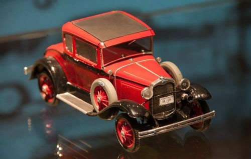 miniatura starodawnego auta koloru czerwonego